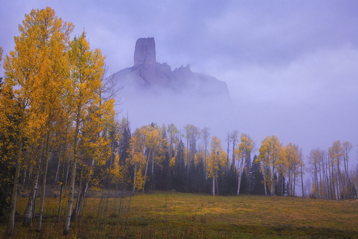 The Rising Chimney Rock emerges from a cold autumn fog.