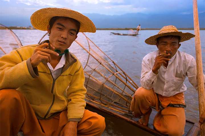 Traditional fishermen on Inle Lake take a break to smoke hand rolled cheroots as the sun begins to set.