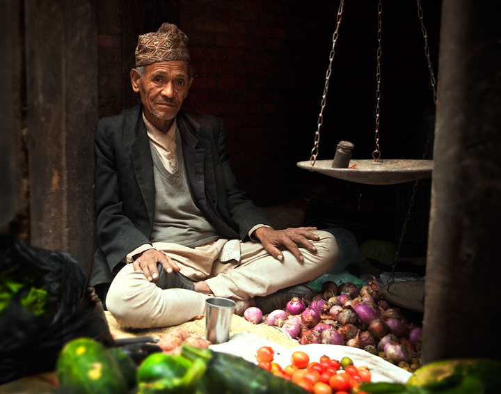 Life in the Balance This friendly fruit and vegetable vendor works the scales in a back alley of the old city of Kathmandu.