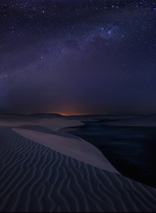 Starlight Dunes The Milky Way galaxy rises over the dunes of Lencois Maranhenses. The long exposure picked up some of the lights of the...