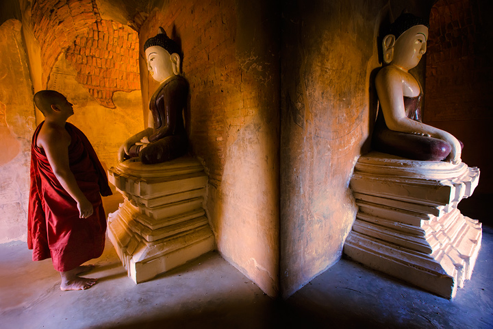 Contemplation A Buddhist monk contemplates a statue of Buddha in a thousand year old temple in Bagan, Burma.