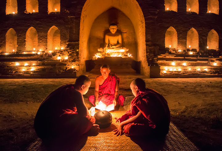 An elder monk teaches the novices at a candlelit temple during Thadingyut  festival (Buddhist lent).