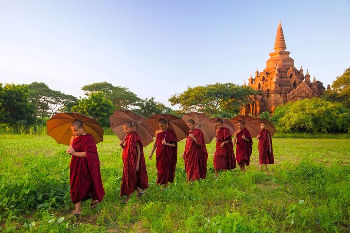 Young monks walk through the rural countryside fields of Bagan, Burma.