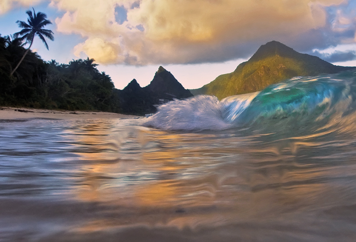 This is a sand level view of small breaking waves crashing on beautiful Ofu Beach, one of the most spectacular beaches in the...