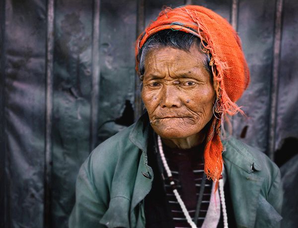 A hardened tibetan woman remains stoic despite being a cultural prisoner in her own land.