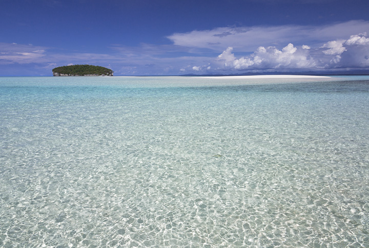 Pristine Beach, Raja Ampat The crystal clear turquoise waters lap against a perfect white sand beach in the remote Raja Ampat islands.