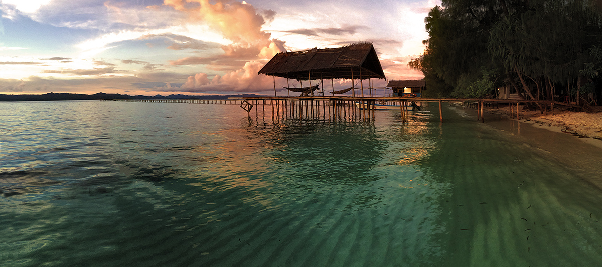 Sunset over the beach and hammock deck of the Yengkoranu Homestay in Raja Ampat, Indonesia. One of the last wild and undiscovered...