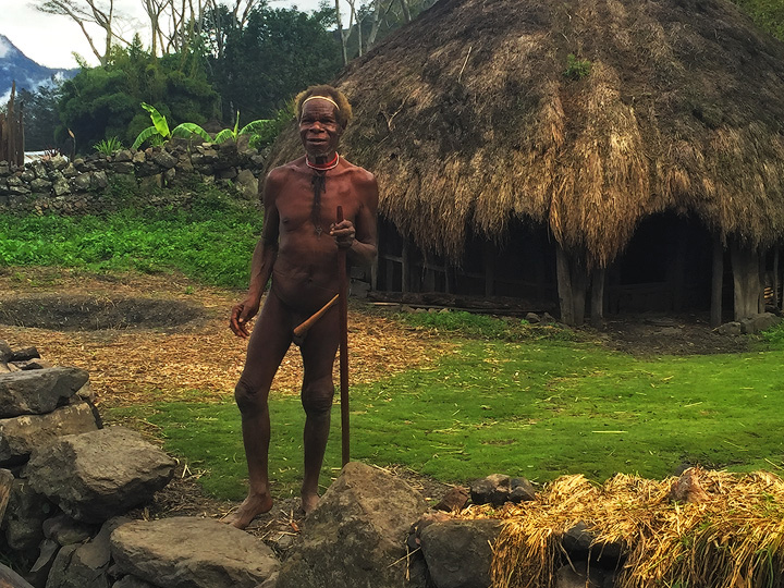 Dani Elder Tribesman. A Dani tribe elder wearing a classic 'Koteca' or penis gourd greets us outside his traditional home in a remote village...