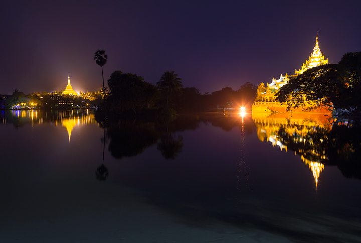 Reflections of Shwedagon Pagoda and Karaweik Dragon Pagoda at dusk. Yangon, Burma.